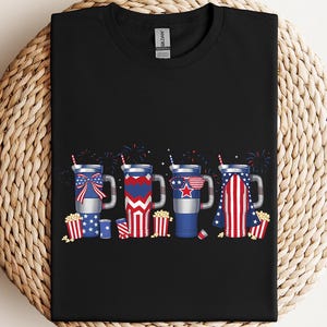 a black t - shirt with fireworks and american flags on it