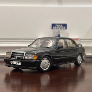 Puede incluir: Un coche modelo Mercedes-Benz 190E negro con una matrícula plateada que dice "S HH 7215".