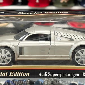 May include: Silver Audi Supersportwagen "Rosemeyer" model car in a black and gold trimmed box. The model is 1:18 scale and features detailed wheels and body design. The box reads "Special Edition".