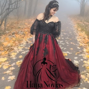 Opala: A bold black & red gothic wedding gown with a sweetheart neckline, lace bodice, tulle sleeves, and a dramatic layered train