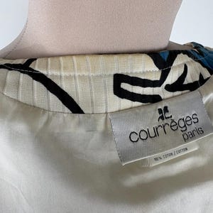 Puede incluir: Una tela de patr&oacute;n blanco y negro con un acento azul. La tela tiene una etiqueta blanca con el texto "Courr&egrave;ges Paris" y "100% Algod&oacute;n/Algod&oacute;n".