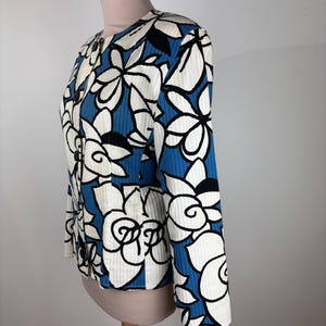 Puede incluir: Una chaqueta con estampado floral azul y blanco con cierre de bot&oacute;n. La chaqueta tiene mangas largas y una silueta ajustada.