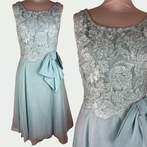 Robe de soirée vintage bleue années 60, dentelle fleurie élégante, sans manches, coupe typique pour cérémonie, événement chic et mariage