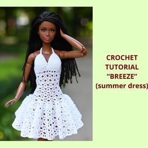 May include: A doll wearing a white crochet halter dress with a flared skirt. The dress has an open, lacy design. The image includes the text "CROCHET TUTORIAL 'BREEZE' (summer dress)". The doll has long black hair and is posed outdoors.