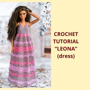 Puede incluir: Una muñeca con un vestido de ganchillo hecho a mano. El vestido presenta un top halter y una falda larga con rayas horizontales en tonos rosa, morado y gris. El texto "CROCHET TUTORIAL 'LEONA' (dress)" se muestra a la derecha.