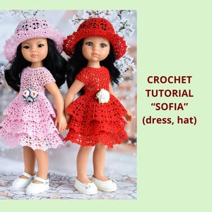 May include: Two dolls wearing handmade crochet dresses and hats. One doll is dressed in a light pink dress and hat, the other in red. The dresses have a tiered skirt design. The text on the right says "CROCHET TUTORIAL 'SOFIA' (dress, hat)".