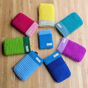 May include: A collection of eight rectangular crochet pouches in various solid colors including yellow, magenta, lime green, teal, light blue, royal blue, and purple. Each pouch features a contrasting color band at the opening and a small white label.