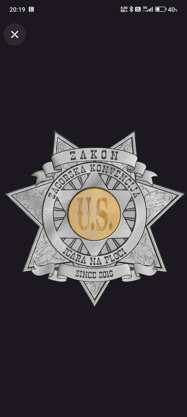 May include: A silver-toned six-pointed star badge featuring a central gold circle with the letters U.S. inscribed. The badge includes banners with the text ZAKON, ZAGORSKA KONVENCIJA, IGARA NA PLOCI, and the year SINCE 2015 in a serif font.