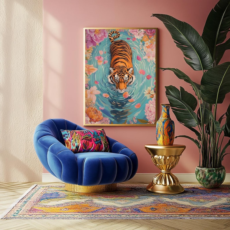 Pode incluir: Uma obra de arte emoldurada retrata um tigre em um lago cercado por flores. Uma cadeira de veludo azul com base dourada est&aacute; em frente &agrave; obra de arte. Uma almofada colorida repousa sobre a cadeira. Uma mesa lateral dourada sustenta um vaso decorativo.