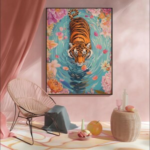 Pode incluir: Uma impress&atilde;o de arte emoldurada com um tigre numa piscina rodeada por flores. O tigre tem listras laranja e pretas. A &aacute;gua &eacute; azul clara com p&eacute;talas de flores cor-de-rosa. A obra de arte &eacute; exibida numa sala rosa com uma cadeira e uma mesa lateral.