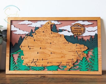Op de afbeelding: Een houten kaart van de Verenigde Staten met alle nationale parken. De kaart is ingelijst in een licht houten lijst en heeft een bruine achtergrond met witte wolken. De tekst "NATIONAL PARKS MAP" staat op de kaart.