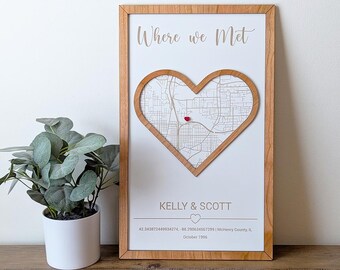 May include: A wooden framed sign with a heart-shaped map inside. The map is of a city with a red pin marking a location. The text on the sign reads "Where we Met", "Kelly & Scott", "42.343872449934274, -88.290634567299 | McHenry County, IL", and "October 1996".