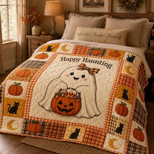 May include: A quilted throw blanket featuring a central illustration of a white ghost wearing a plaid bow and holding a jack-o'-lantern bucket. The text "Happy Haunting" is printed above the ghost. The border displays orange pumpkins, black cats, and yellow crescent moons on a plaid background.