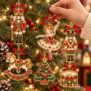 May include: A collection of five hanging Christmas tree ornaments featuring a nutcracker, a ballerina, a rocking horse, a decorated pine tree, and a drum. Each piece is crafted with red, green, and gold metallic accents and red bows.