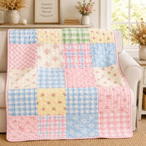 May include: A patchwork quilt featuring a grid of squares with various patterns including blue and white gingham, pink and white plaid, yellow with small pink floral prints, and light blue with white star motifs, finished with a pink border.