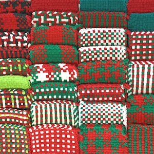 May include: Twenty-four handmade pot holders in various red, green, and white woven patterns.
