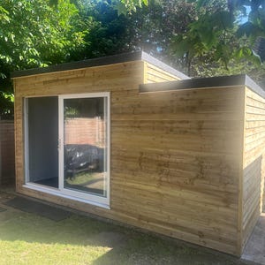 May include: A wooden garden shed with a sliding glass door. The shed has a light brown wood exterior and a black roof.