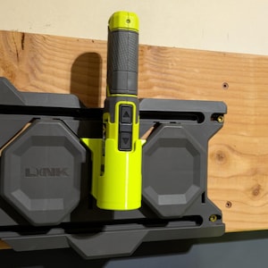 May include: A black and green tool holder with a yellow and black tool attached. The tool holder has the word "LINK" printed on it.