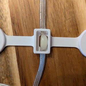 May include: White LED light strip with a white plastic connector. The light strip is connected to a white plastic connector with a white LED light in the center.