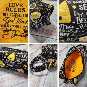 May include: A black and yellow fabric zippered pouch with a bee theme. The pouch has a variety of bee-themed designs, including bees, honeycombs, and flowers. The pouch is lined with a yellow fabric and has a zipper closure. The pouch has the text "Hive Rules" and "Bee Respectful" on the front. The pouch has the text "Bee Kind" and "Bee Positive" on the back.