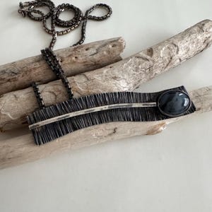 Collar vintage artesanal de plata de ley con colgante y piedra azul y gris.