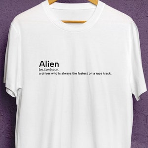 Peut inclure: T-shirt blanc avec un graphique noir qui dit "Alien [el.ee.ən] nom. un pilote qui est toujours le plus rapide sur une piste de course."