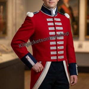 May include: A red military-style jacket featuring a high navy blue collar, white trim, and silver buttons arranged in vertical rows. The garment includes white shoulder epaulets and navy blue cuffs. The text KiltjacketsonlineShop is visible.