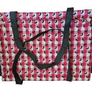 May include: A red and white checkered tote bag with black polka dot straps. The bag features a repeating pattern of black ant illustrations on the checkered fabric. The tote bag is designed for carrying items.