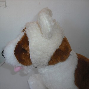 May include: White plush dog toy with brown patches and a white plush hat with floppy ears.