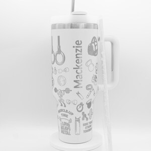 Pu&ograve; includere: Bicchiere isolante bianco con manico, cannuccia e coperchio. Il bicchiere &egrave; decorato con grafiche a tema fitness e il nome "Mackenzie". Include immagini di pesi, anelli da palestra e frasi motivazionali.