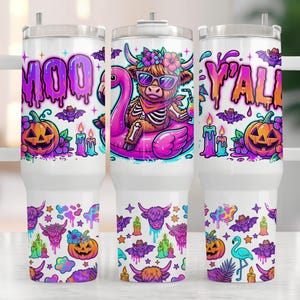 May include: White tumbler with a Halloween theme. The design includes the words "MOO Y'ALL" in purple and orange, a skeleton cow on a flamingo float, pumpkins, bats, and candles. The tumbler has a white handle and a clear lid.