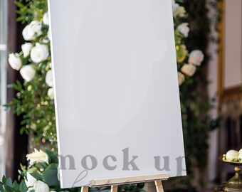 May include: A white blank sign on an easel with a floral backdrop. The sign is perfect for displaying messages, announcements, or artwork.