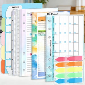 May include: A set of planner inserts featuring a blue tabbed divider marked "TODAY", a clear ruler, and pages for monthly calendars, budgeting, and notes. The inserts also include colourful sticky notes. Measurements are in centimetres.