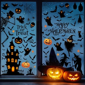 Puede incluir: Un conjunto de pegatinas de Halloween para ventanas con siluetas negras de casa encantada, esqueleto, fantasmas, murciélagos, arañas y calabazas. El texto dice Trick or Treat y Happy Halloween. Dos calabazas naranjas frente al cristal.