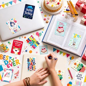 May include: A collection of colorful stickers and cards with birthday and celebratory themes. Designs include a cat, cake, balloons, and the phrases "Happy Birthday" and "Best Day Ever." A laptop, book, and cake are also visible.