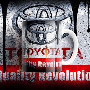 Puede incluir: Una taza de cerámica blanca con el logotipo de Toyota y las palabras "Quality Revolution" en rojo y blanco. La taza tiene un diseño desgastado, estilo grunge, con gotas negras y un fondo texturizado.
