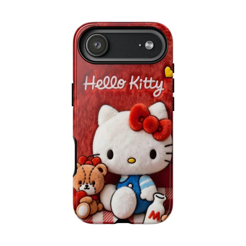 May include: Red phone case featuring Hello Kitty with a red bow, blue overalls, and a teddy bear. The case has the words "Hello Kitty" in white script. The background is red with a textured appearance.