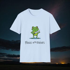 Maglietta unisex morbida con rana assurda dei cartoni animati e coltelli, maglietta con rana arrabbiata, contorni audaci, maglietta con tonalità verde-blu, maglietta con meme di rane e coltelli