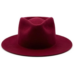May include: A burgundy fedora hat with a wide brim. The hat has a structured crown and a soft, felt-like texture. The hat is a solid color and is suitable for various occasions.