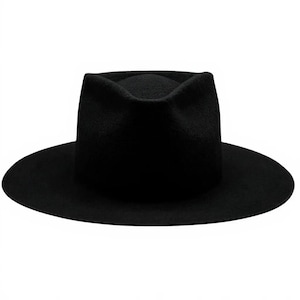 Może przedstawiać: Czarny kapelusz typu fedora z szerokim rondem. Kapelusz ma strukturalną koronę i klasyczny, ponadczasowy design. Kapelusz wykonany jest z miękkiego materiału przypominającego filc.