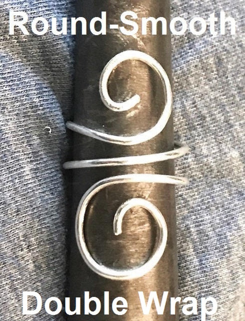May include: Silver double wrap hair ring with a round, smooth design. The ring is made of wire and has two spirals.