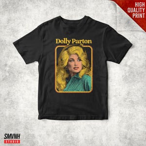 May include: Black t-shirt featuring a vintage-style portrait of Dolly Parton. The image is framed in a yellow border with the text "Dolly Parton" above the portrait. The words "High Quality Print" are in the upper right corner.
