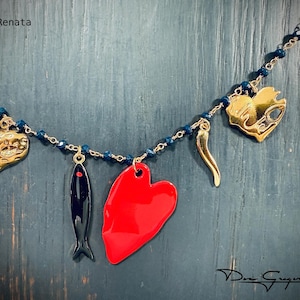 May include: A gold chain necklace with blue crystal beads and various charms, including a red heart, a gold heart, a gold chili pepper, and a black fish.