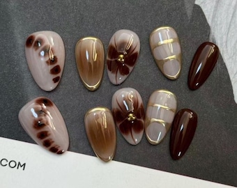 Unghie finte romantiche per una serata speciale, design in gel floreale, tonalità oro cromato bordeaux e marrone, lunghezza media o corta, a mandorla, set per l'inizio dell'autunno.