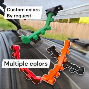 May include: Multiple colored brackets in green, red, orange, and black are displayed. The text "Custom colors By request" and "Multiple colors" are visible. The brackets are mounted on a dark surface.
