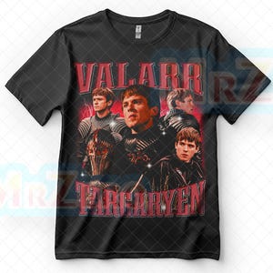 以下が含まれることがあります： 「VALARR TARGARYEN」の赤い文字と人物の複数の画像が特徴の黒いTシャツ。背景には赤い稲妻のエフェクトがあり、ヴィンテージ感を演出しています。
