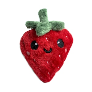 May include: A red plush strawberry toy with a green plush stem and leaves. The strawberry has a smiling face with black eyes and a black mouth.