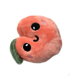 May include: A plush peach-colored heart-shaped toy with a smiling face and green leaf. The toy has black eyes and a stitched-on smile.