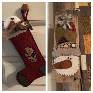 May include: Two handmade felt Christmas ornaments. One is a red stocking with a felt bird on top. The other is a snowman with a brown felt nose and black eyes.