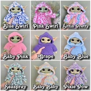 Puede incluir: Nueve conjuntos de capucha tejidos a crochet en varios colores y patrones para un peque&ntilde;o juguete de peluche. Los conjuntos incluyen remolino azul, remolino rosa, sentado bonito, rosa beb&eacute;, uva, azul beb&eacute;, roc&iacute;o de mar, beb&eacute; beb&eacute; y pixie pow.